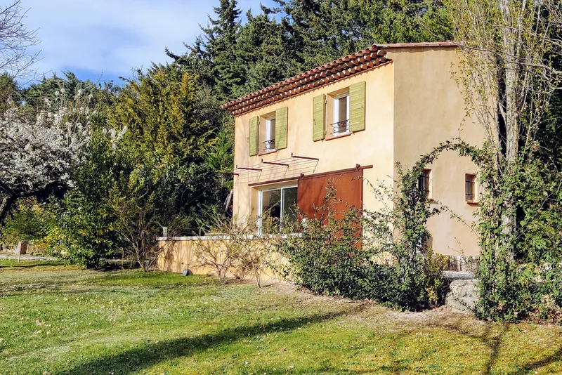 Façade latérale du Mazet et sa toiture de tuiles dans le jardin arboré