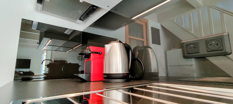Machine à café rouge et bouilloire sur le plan de travail de la cuisine