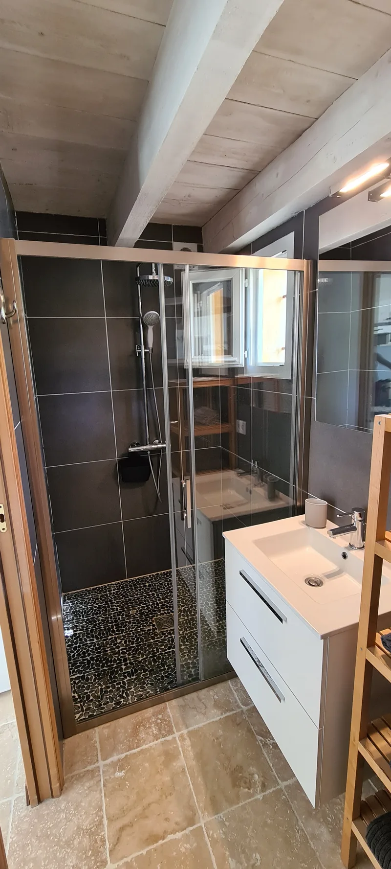 Salle d’eau avec vasque blanche, miroir et douche vitrée